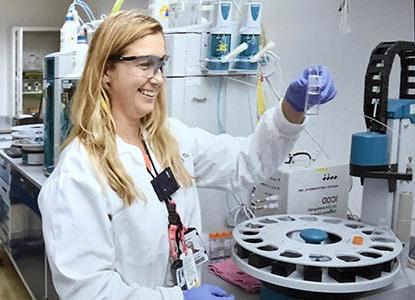 Hartwick alumna Diana Sardelis Simcox '17 in laboratory looking at samples